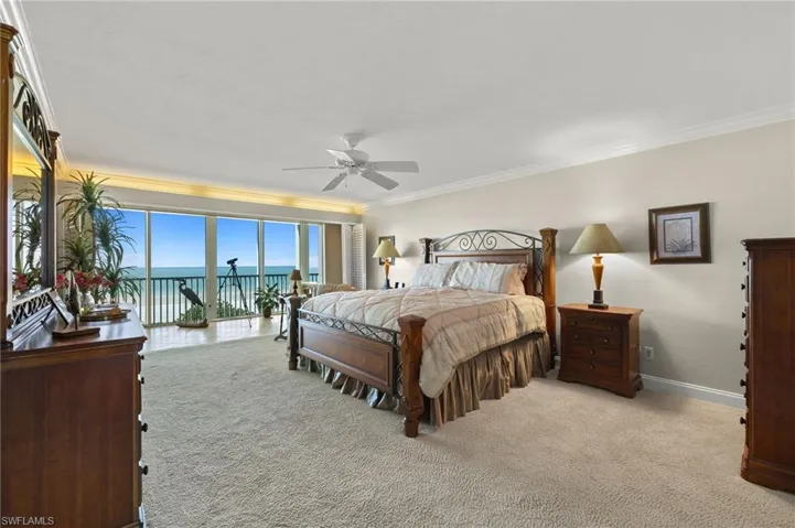 Carpeted bedroom featuring a water view, ceiling fan, access to outside, and crown molding
