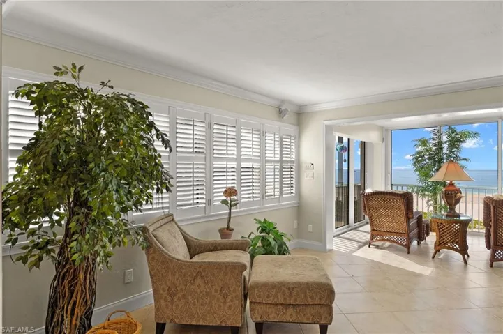 Sitting room with ornamental molding, a water view, and light tile patterned floors
