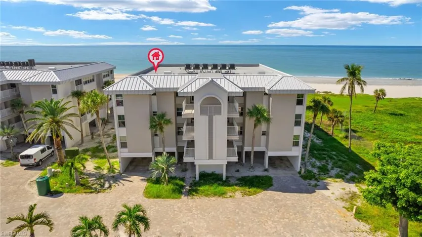 View of front of property with a water view and a beach view