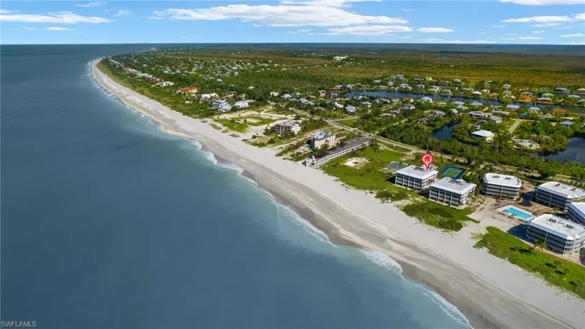 Birds eye view of property featuring a view of the beach and a water view
