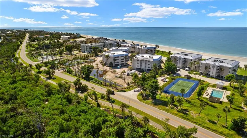 Birds eye view of property featuring a beach view and a water view