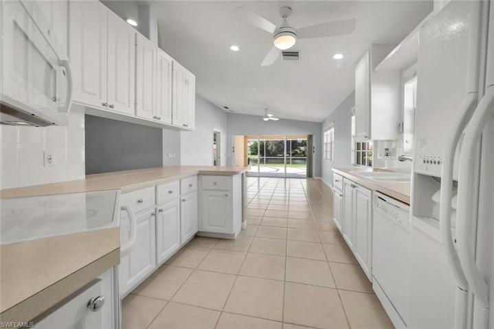 Tidy kitchen with white cabinetry.