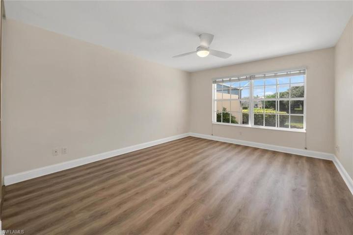 Sunny primary bedroom with new luxury vinyl plank flooring.