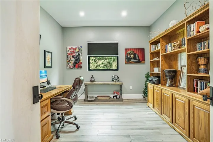 Office area with light wood-style floors and recessed lighting