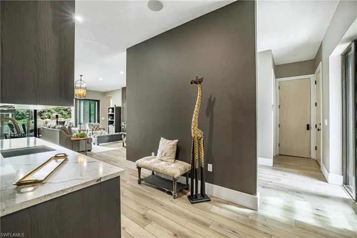 Hallway featuring light wood finished floors, recessed lighting, and a chandelier