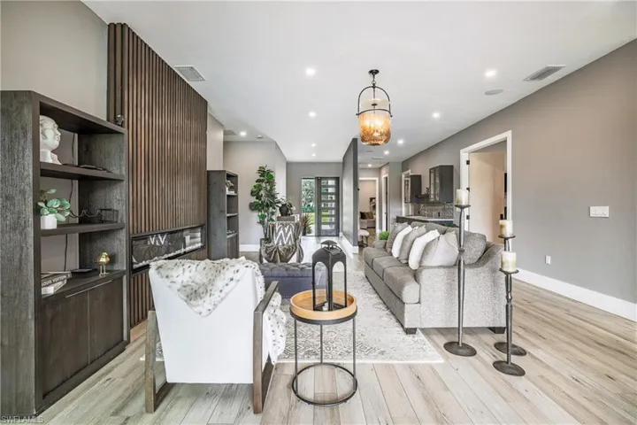 Living area with a chandelier, light wood-style flooring, and recessed lighting