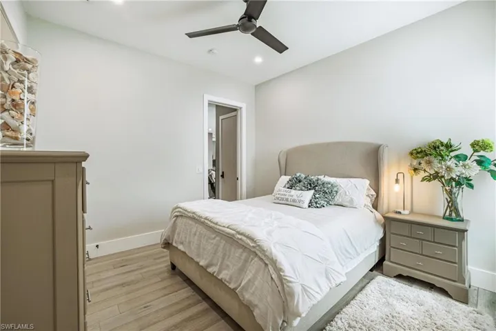 Bedroom with light wood-style floors, ceiling fan, and recessed lighting