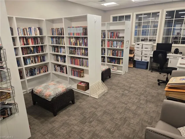 Living area with carpet flooring and a drop ceiling
