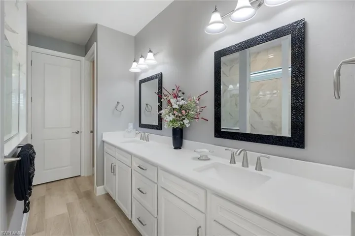 Bathroom with hardwood / wood-style floors, large vanity, and double sink