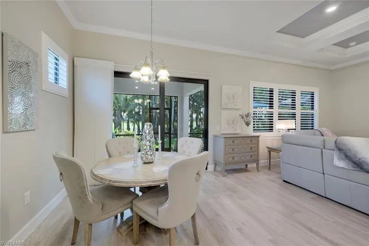 Dining room featuring light hardwood / wood-style floors, crown molding, and a wealth of natural light