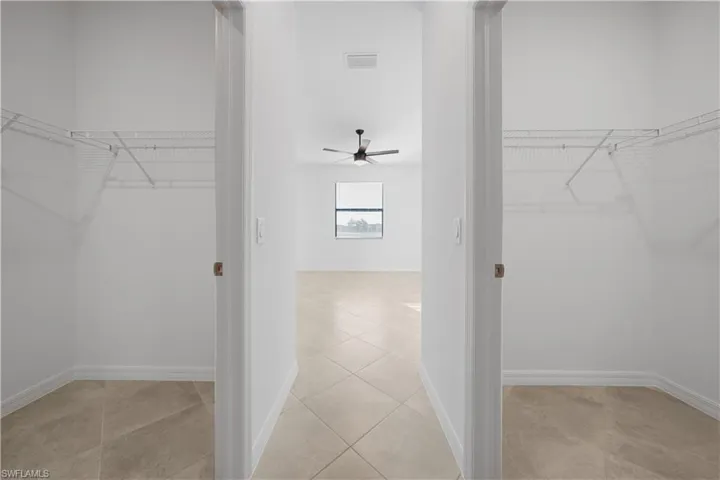 Walk in closet with a ceiling fan and light tile patterned flooring