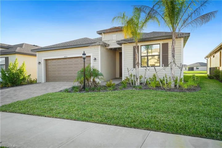 View of front of property featuring decorative driveway, a front lawn, an attached garage, and a shingled roof