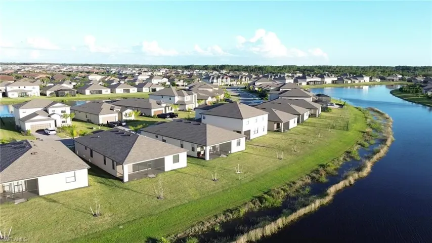 Aerial perspective of suburban area featuring a nearby body of water