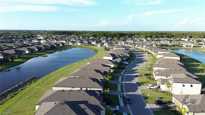 Aerial perspective of suburban area featuring a nearby body of water