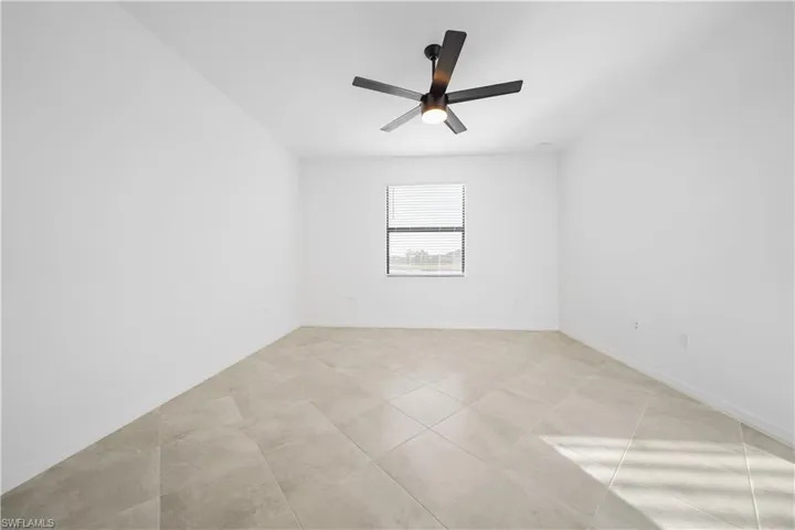 Unfurnished room featuring a ceiling fan and light tile patterned flooring