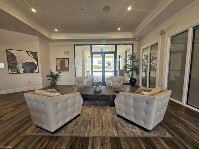 Living area featuring recessed lighting, crown molding, dark wood finished floors, and a tray ceiling