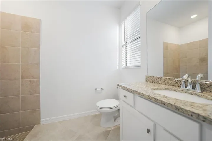 Full bath featuring vanity and light tile patterned flooring