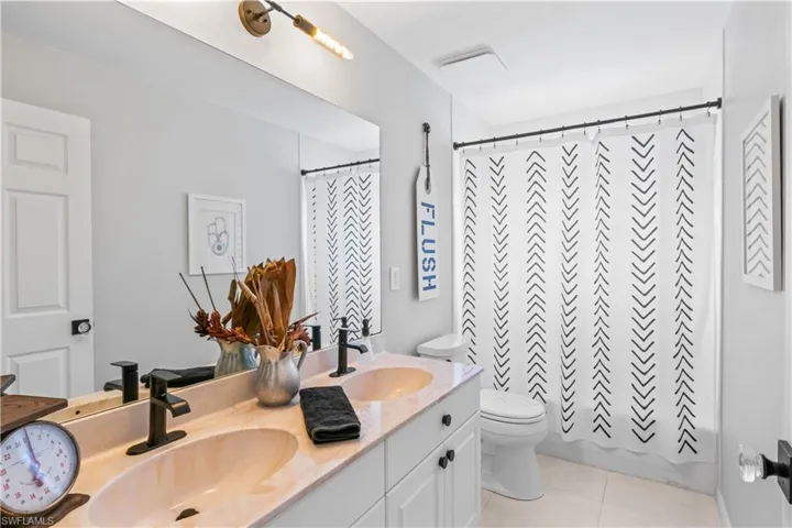 Bathroom with double vanity and tile patterned flooring