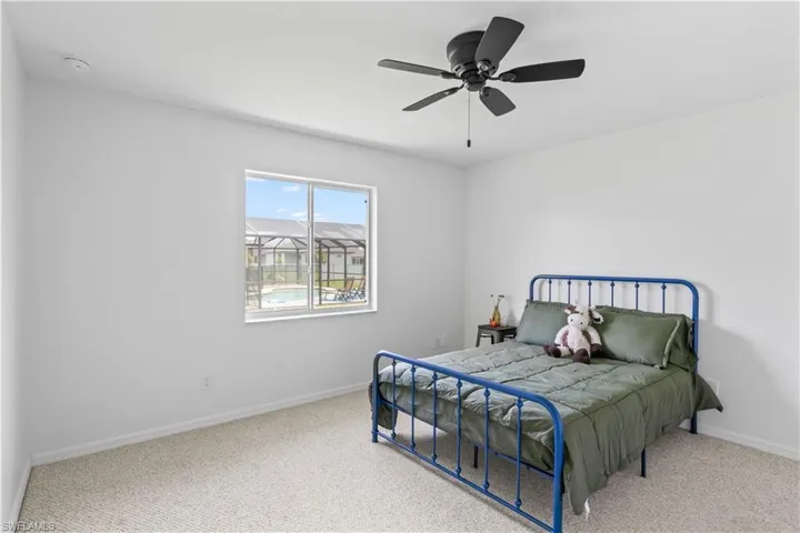 Carpeted bedroom featuring baseboards and a ceiling fan