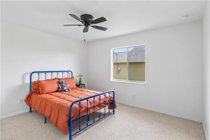 Carpeted bedroom featuring baseboards and ceiling fan