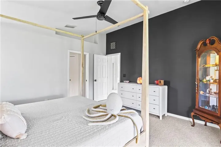 Carpeted bedroom with a ceiling fan