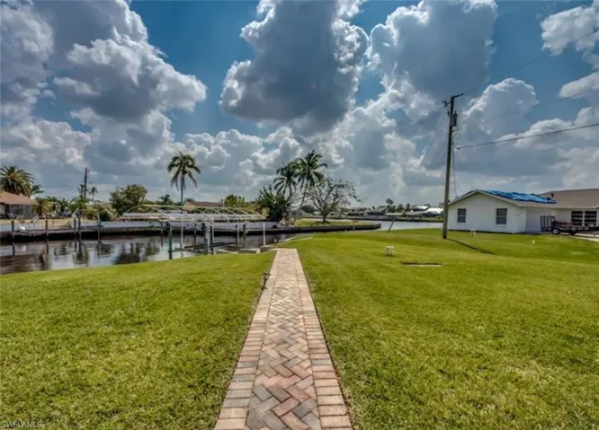 View of yard with a dock and a water view