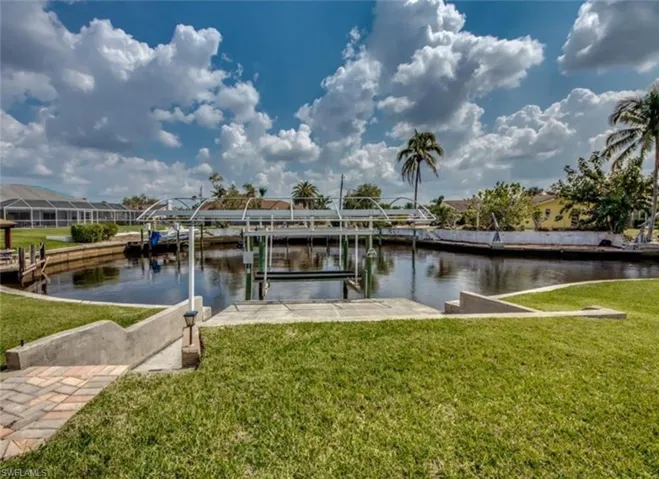 Dock area featuring a water view and a lawn