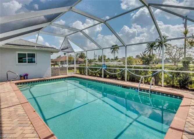 View of swimming pool featuring a lanai