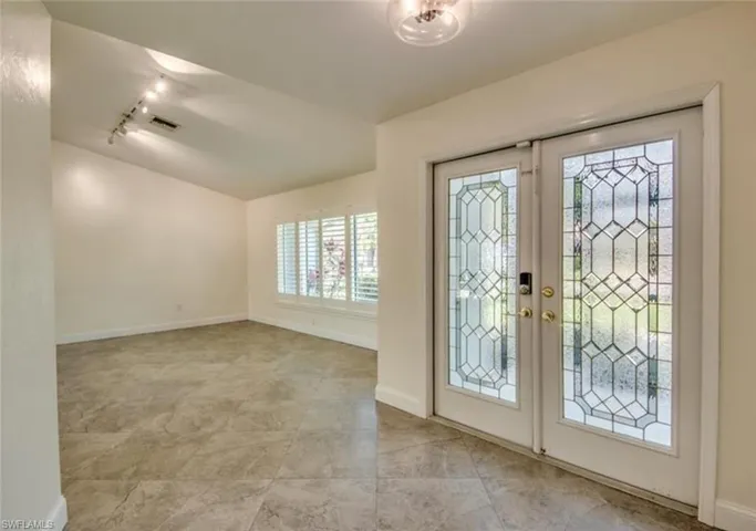Tiled foyer featuring french doors