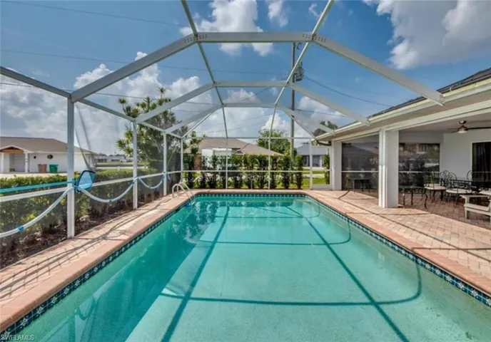 View of swimming pool with ceiling fan, a lanai, and a patio area