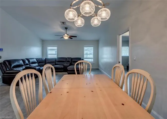 Dining room with ceiling fan with notable chandelier