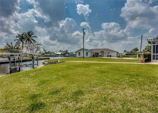 View of yard with a water view and a boat dock