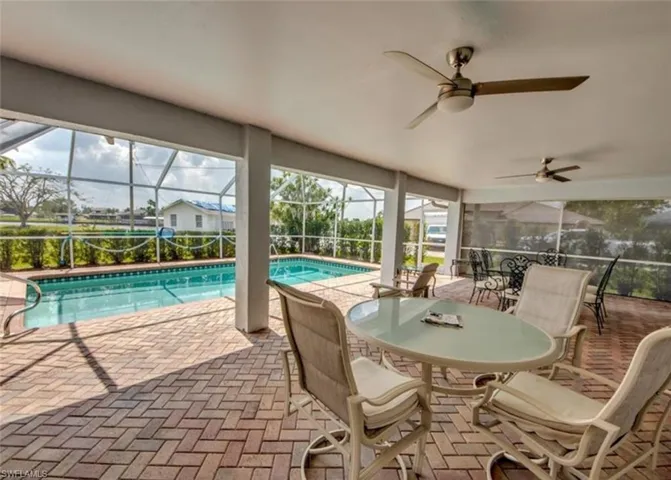 View of swimming pool featuring ceiling fan, a patio area, and a lanai