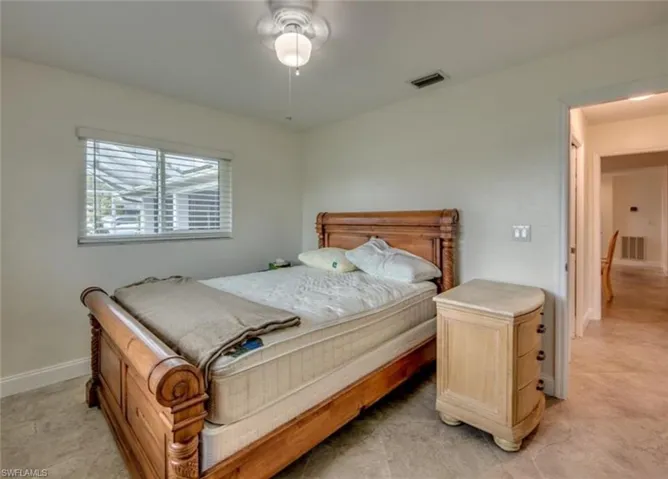 Bedroom with ceiling fan and light tile patterned floors