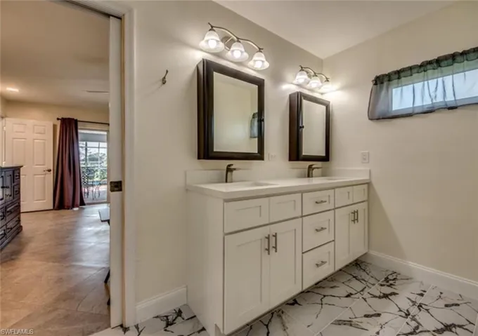 Bathroom with double vanity and tile patterned floors