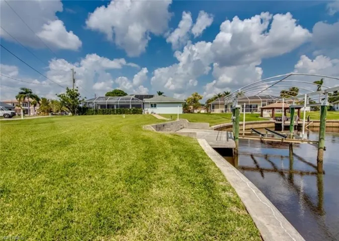 View of community with a dock, a water view, and a yard