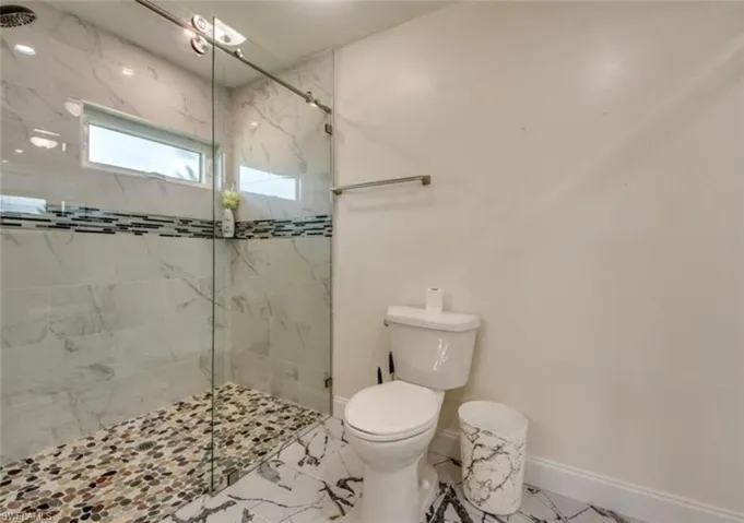 Bathroom with tile patterned flooring, an enclosed shower, and toilet