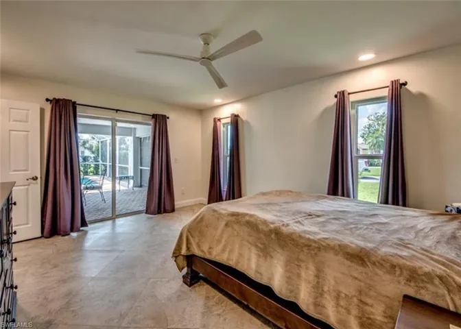 Tiled bedroom featuring ceiling fan and access to exterior