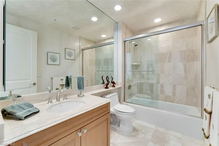Full bathroom with shower / bath combination with glass door, toilet, vanity, and recessed lighting
