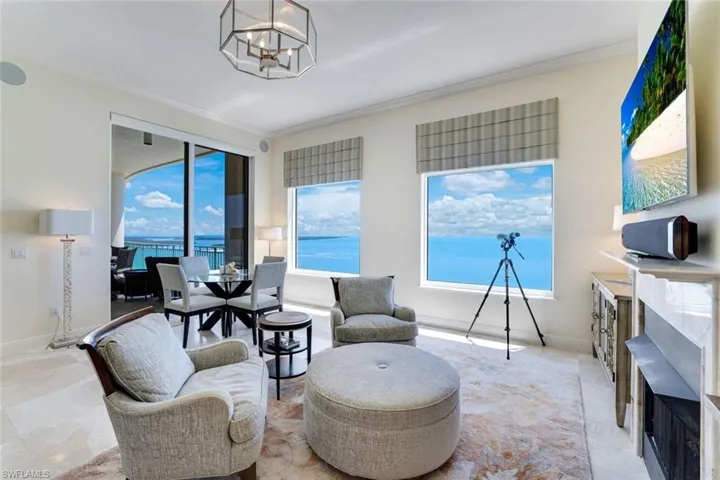 Living area with crown molding, a chandelier, and baseboards