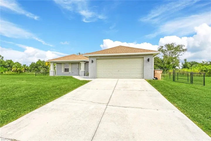 View of front facade featuring a front lawn and a garage
