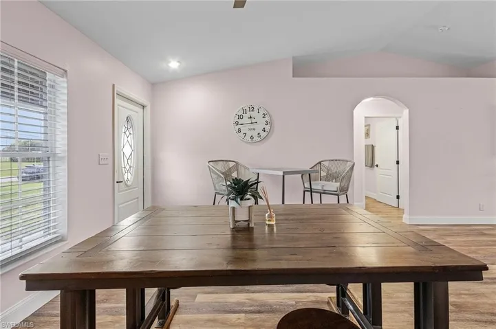 Dining space featuring light wood-type flooring and vaulted ceiling