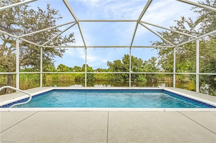 View of pool featuring a lanai, a patio, and a water view