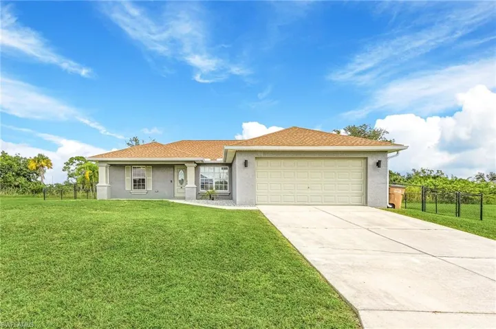 Single story home with a front yard and a garage