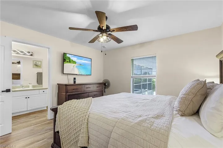 Bedroom with light wood-type flooring, sink, ceiling fan, and ensuite bathroom
