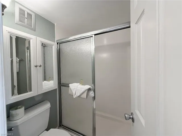 Bathroom featuring a shower stall and toilet