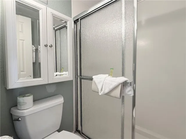 Full bath with toilet and a shower stall