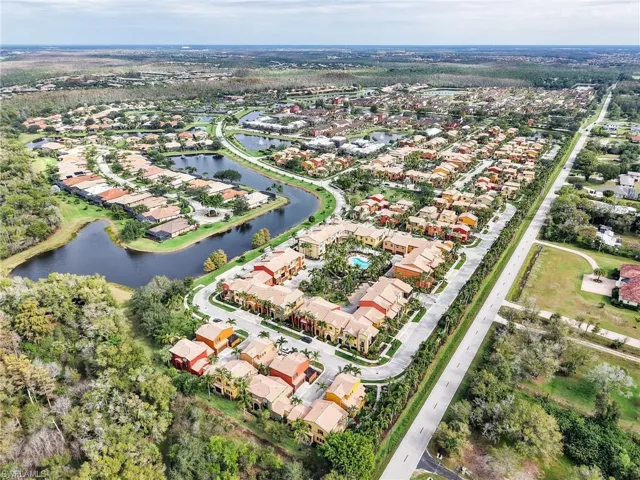 Aerial view of property and surrounding area featuring a large body of water and nearby suburban area