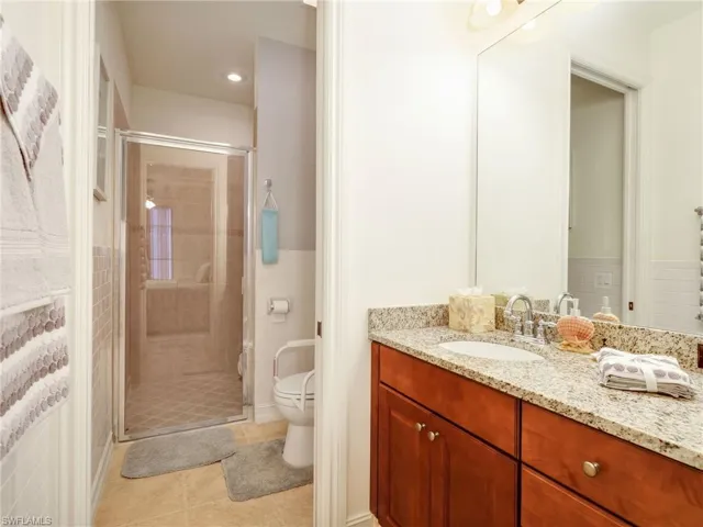 Full bath featuring vanity, a stall shower, light tile patterned floors, and recessed lighting
