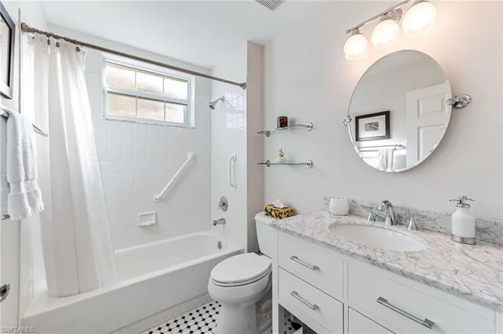 Full bathroom with vanity, shower / bathtub combination with curtain, tile patterned floors, and toilet